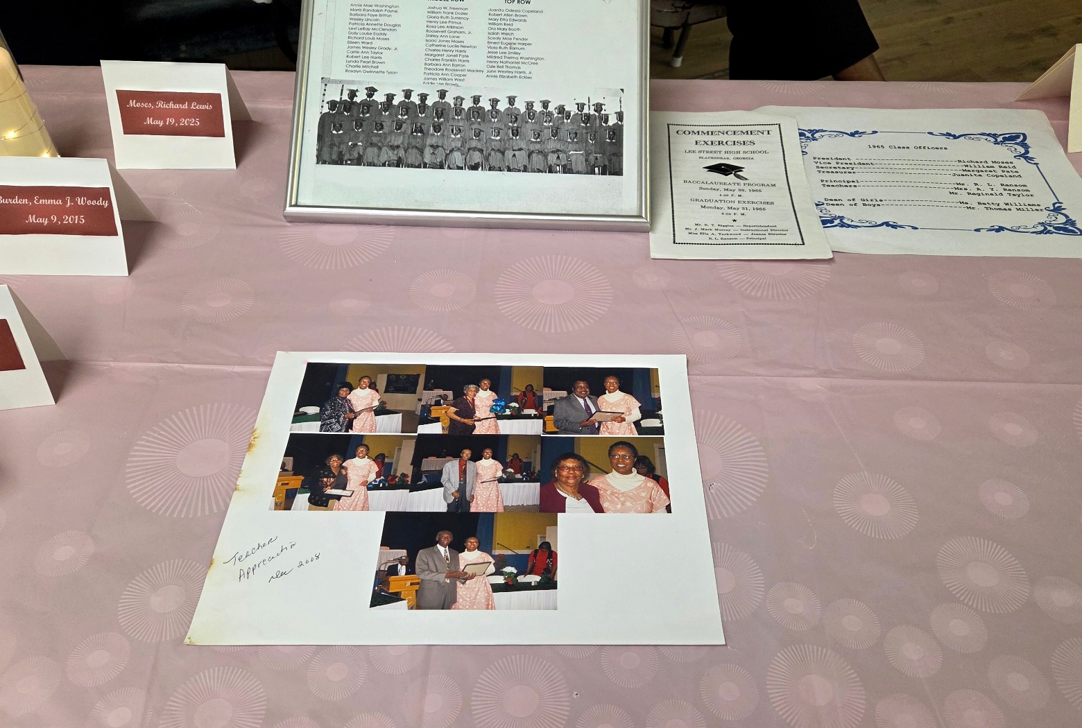 Memorial display table with candle, class keepsakes, commencement materials, and tribute items.
